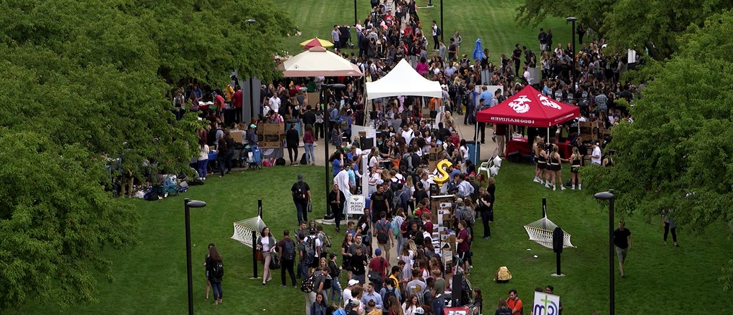 aerial view image of crowds of students and tents surrounded by trees